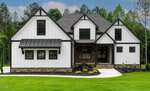 A modern two-story house at 1225 Red Cedar Court in Youngsville, featuring white siding, black trim, a covered front porch, large windows, and a landscaped yard. Surrounded by trees and greenery under a partly cloudy sky.