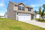 Two-story beige house with white trim, double garage, and driveway, sits on a grassy lot under a blue sky in the charming Oxford neighborhood. Located at 111 Hybrid Street, other similar houses are visible in the background.