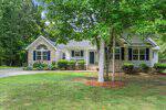 Single-story Oxford house with brick and siding exterior, black shutters, arched windows, front porch, and a neatly landscaped yard with trees and bushes at 3637 Ashton Glen Lane.
