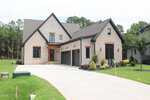 Modern two-story house with light brick and gray siding, three-car garage, and a clean, wide driveway located at 15 Geranium Drive in Youngsville. The yard is landscaped with green grass, bushes, and small trees. The home is surrounded by woods.