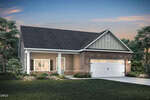 Single-story house with gray siding, stone accents, and a two-car garage at 30 Arch Way, Youngsville. The home has a gabled roof, front porch, and landscaped yard with green grass and shrubs, surrounded by trees at dusk.