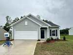 Single-story house with light gray siding, white trim, and a front-facing garage situated at 200 Buckthorn Drive in Youngsville. Concrete driveway leads to the garage. Grass lawn with sparse landscaping surrounds the house. Sky is overcast.