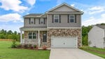 This charming two-story suburban house at 35 Rolling Hills Drive, Youngsville, features a blend of stone and gray siding, a welcoming covered front porch, a spacious double garage, and a concrete driveway. It's set on a well-kept lawn with shrubs and trees providing a picturesque backdrop.