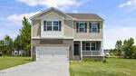 Two-story beige house with white trim, a double garage, and a covered front porch located at 45 Rolling Hills Drive in Youngsville. The front yard has green grass and a concrete driveway. Trees and a blue sky with clouds are visible in the background.