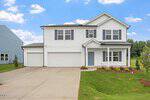 Two-story suburban house with white siding, double garage, and covered entry located at 130 Buckthorn Drive in Youngsville. Concrete driveway and small landscaped yard with green grass and shrubs. Blue sky with scattered clouds in the background.