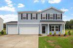 Two-story light blue house with black shutters, a black front door, and a three-car garage located at 140 Buckthorn Drive in Youngsville. The front yard has small bushes and a patchy lawn. The driveway and sidewalk are concrete. Sky is mostly clear with a few clouds.