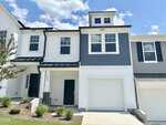 A two-story townhouse with white and gray siding, black door, attached single-car garage, small front yard, and a concrete driveway under a partly cloudy sky. Located in Franklinton, the house number 216 is visible beside the front door, just down the street from 218 Alberta Drive.