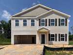 A two-story beige house with black shutters, an attached two-car garage, and a small covered front entrance sits at 240 Buckthorn Drive in Youngsville. The yard is unfinished with dirt and construction barriers, while trees and grass are visible in the background.