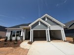 A newly constructed single-story house at 88 Moon Flower Walk, Youngsville, features a double garage, gray and white exterior siding, gable roof, and a concrete driveway. There is minimal landscaping with small shrubs in front of the house.