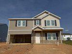 Two-story beige house with white trim and stone accents at 8 Silverbell Court, Youngsville, featuring an attached two-car garage, front porch with pillars, and multiple windows. The yard is bare dirt with no landscaping. Sky is clear with scattered clouds.