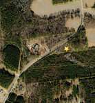 Aerial view of 0 Dorsey Road curving through wooded and cleared areas near Louisburg, with property boundary lines visible; a yellow star marks a location near the road, and several buildings and ponds are scattered nearby.