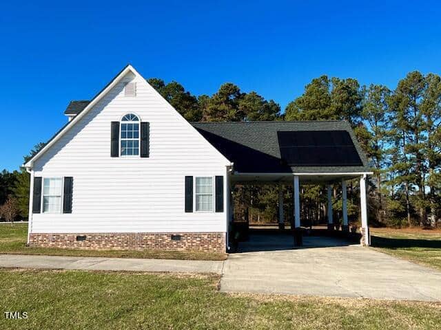 White single-story house with a carport on a clear day.