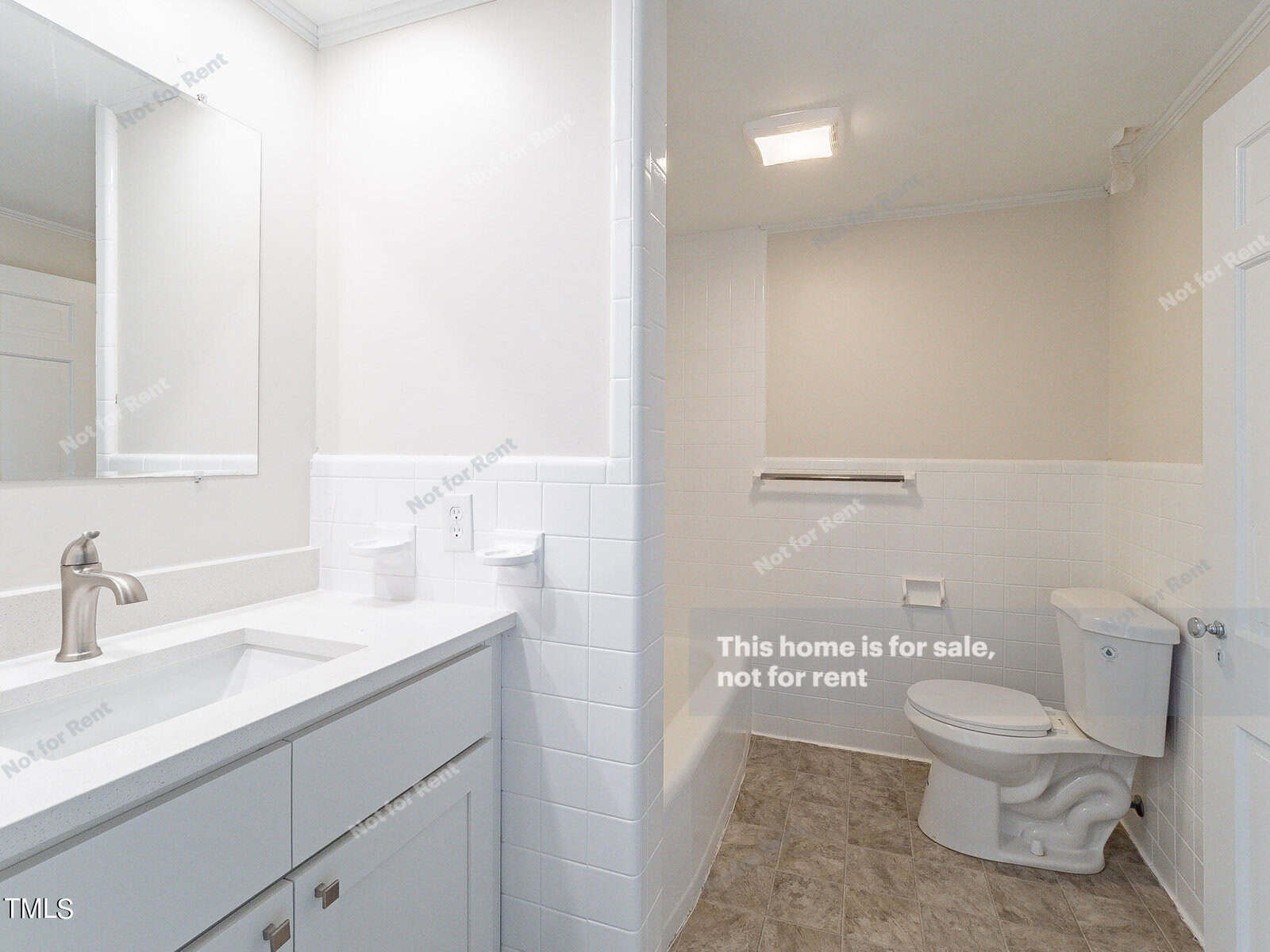 Modern bathroom featuring a white vanity with a large mirror, a toilet, and a tiled shower area. The walls are adorned with "Not for Rent" text, and the space is illuminated by ceiling lights.