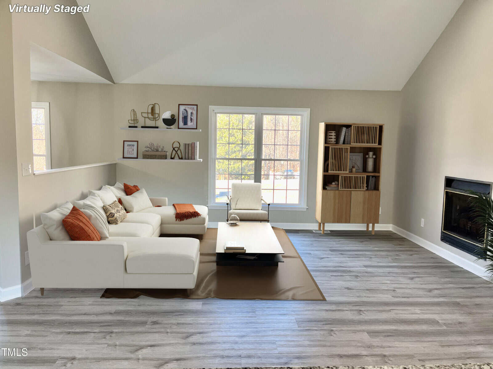 A neatly arranged living room with a white sofa, a fireplace, and a bookshelf, featuring a neutral color palette and natural light streaming in through the windows.