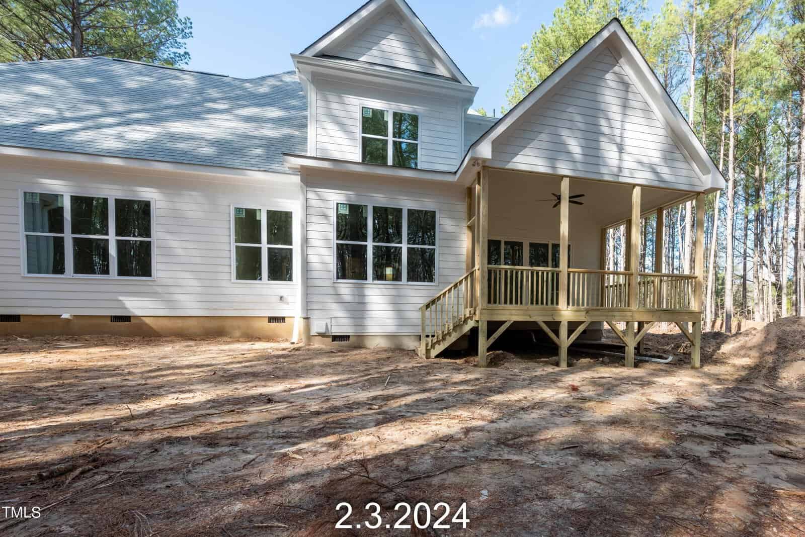 A modern, two-story white house with a spacious porch and large windows, set against a backdrop of tall trees. The date "2.3.2024" is in the foreground.