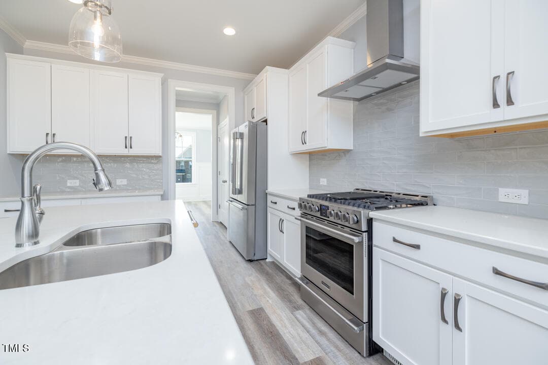 A modern kitchen with white cabinetry, stainless steel appliances, a subway tile backsplash, and quartz countertops.