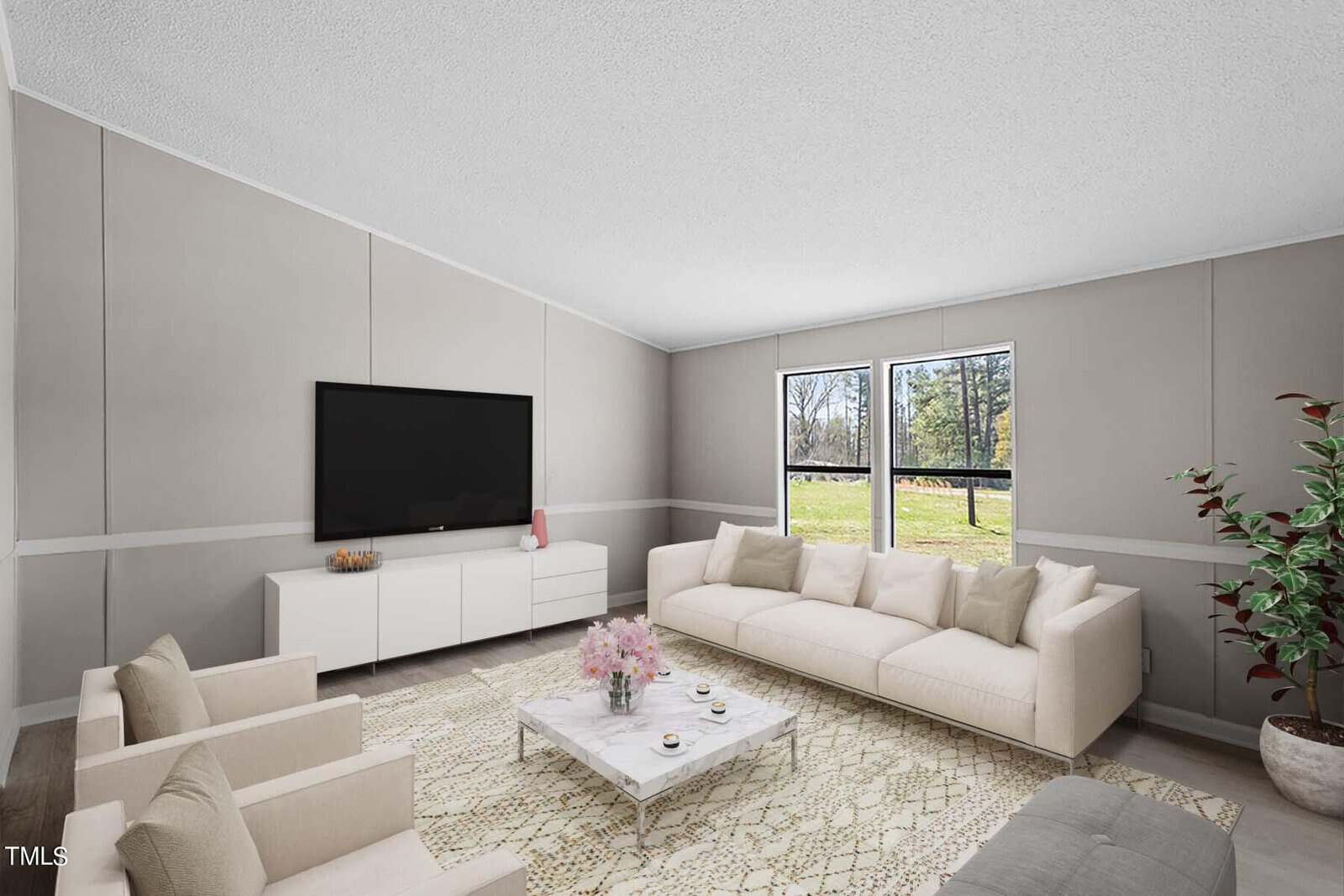 A modern, spacious living room with a beige sofa, matching armchairs, a white entertainment unit, and a flat-screen tv. large windows offer a view of greenery outside. a decorative rug and plant add warmth.