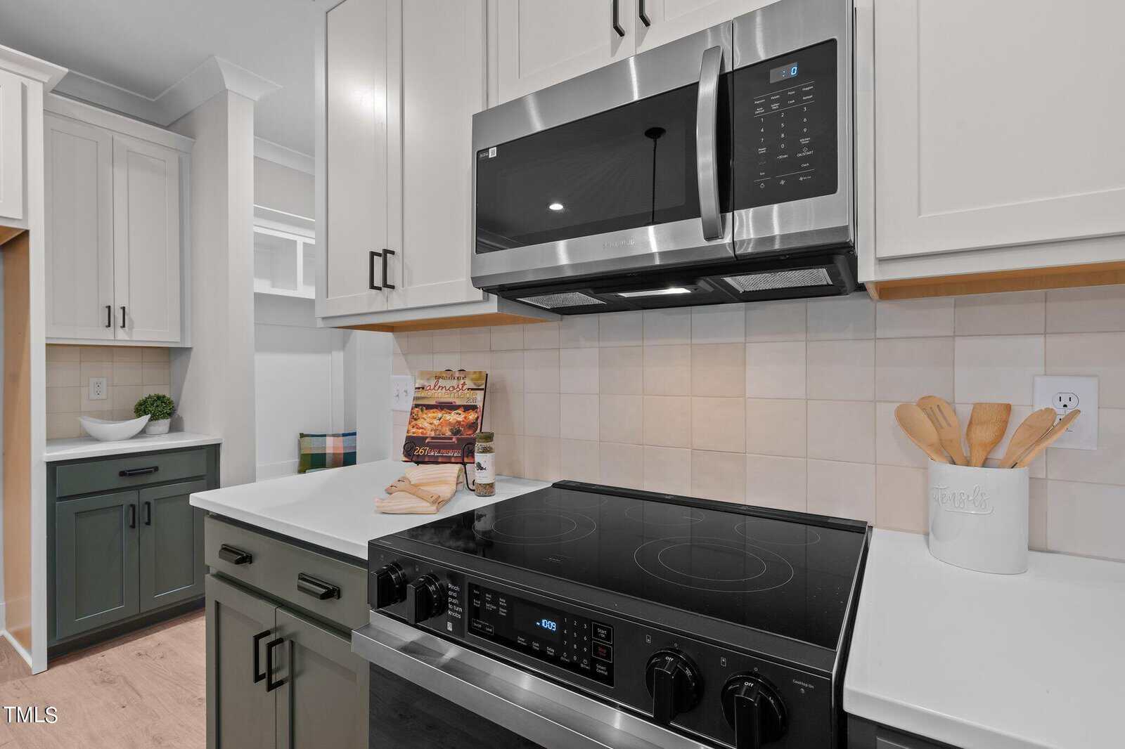 A kitchen with a microwave oven and white cabinets.