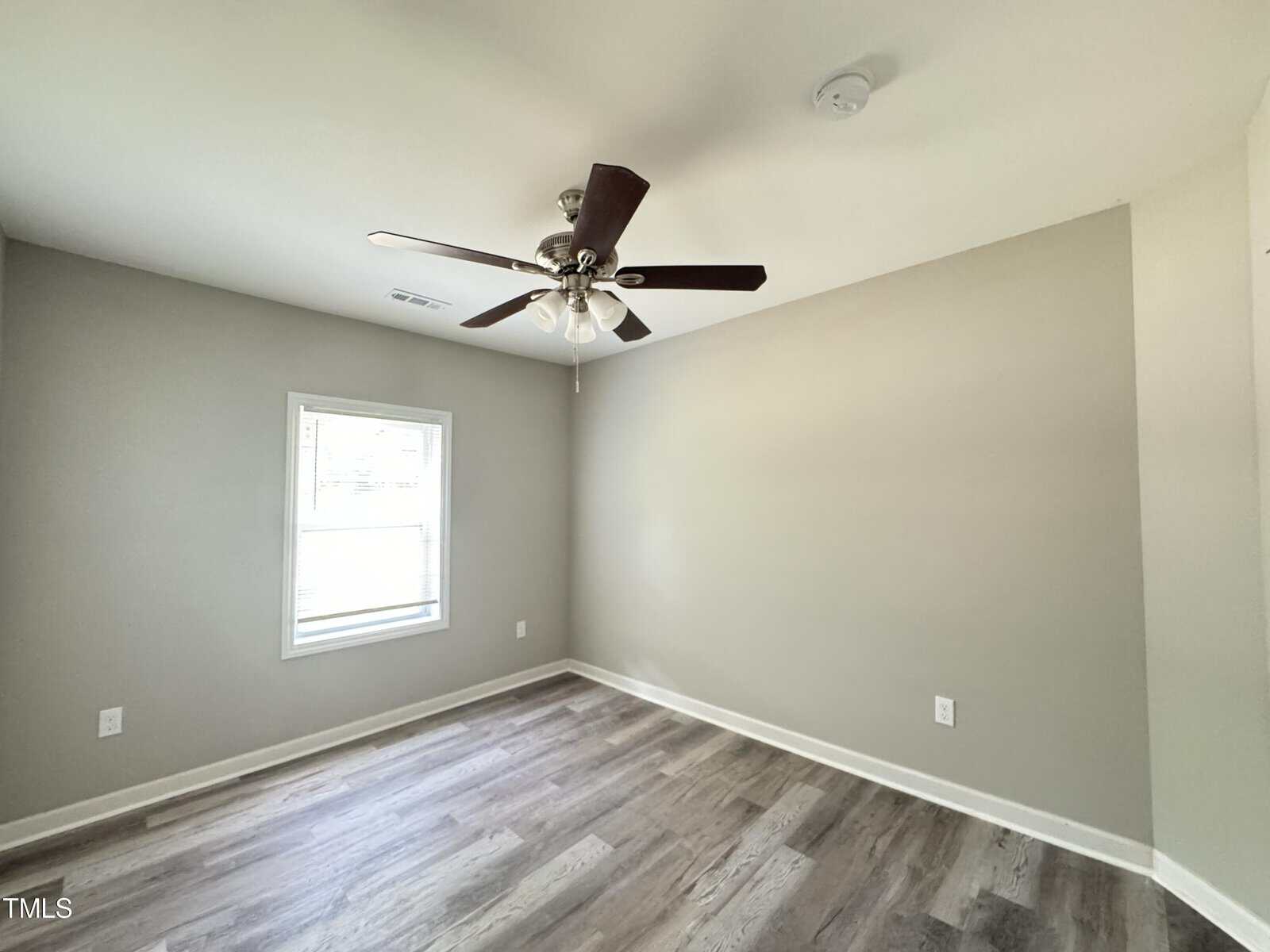 A room with a ceiling fan and a window.