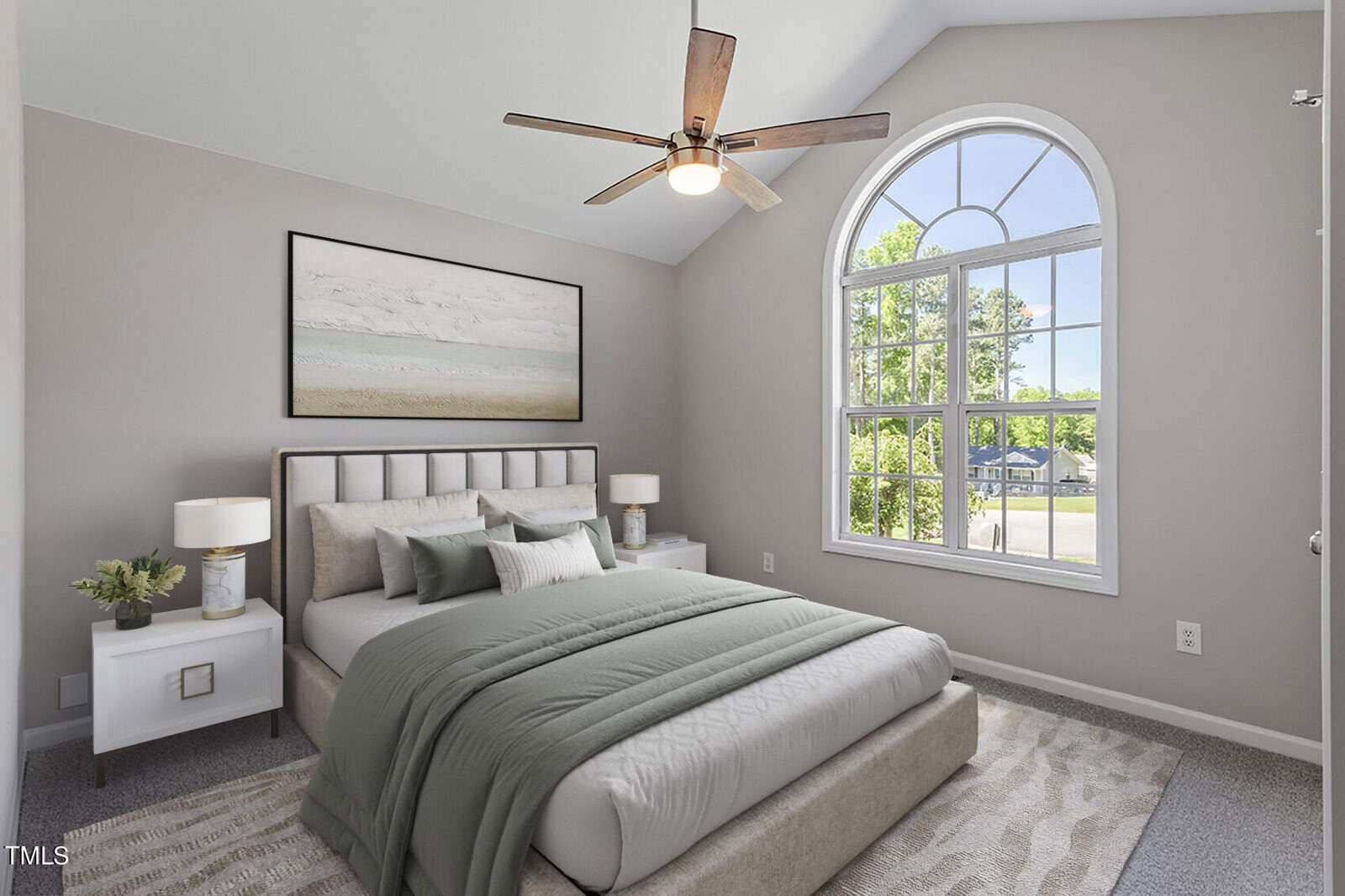 A modern bedroom with a large arched window, allowing natural light to illuminate the space. It features a neatly made bed with green bedding, matching lamps on side tables, a ceiling fan, and a beach-themed painting above the bed.