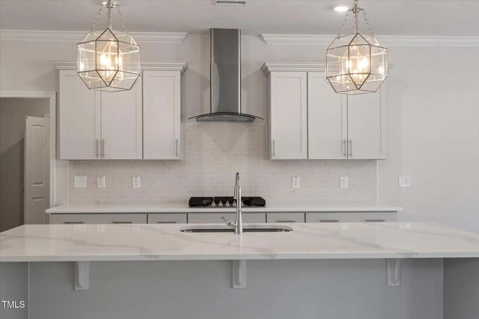 A kitchen with white cabinets and a white countertop.