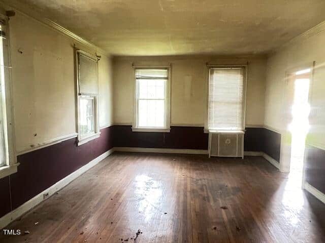 A room with a wood floor and windows.