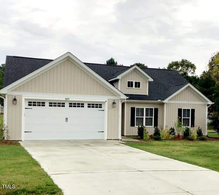 The single-story house at 105 Averly Court features light beige siding and a dark gray roof. The front has a white double garage door with a small window above and several windows on the right, typical of homes in Stem. A concrete driveway leads to the garage and a neatly trimmed lawn.