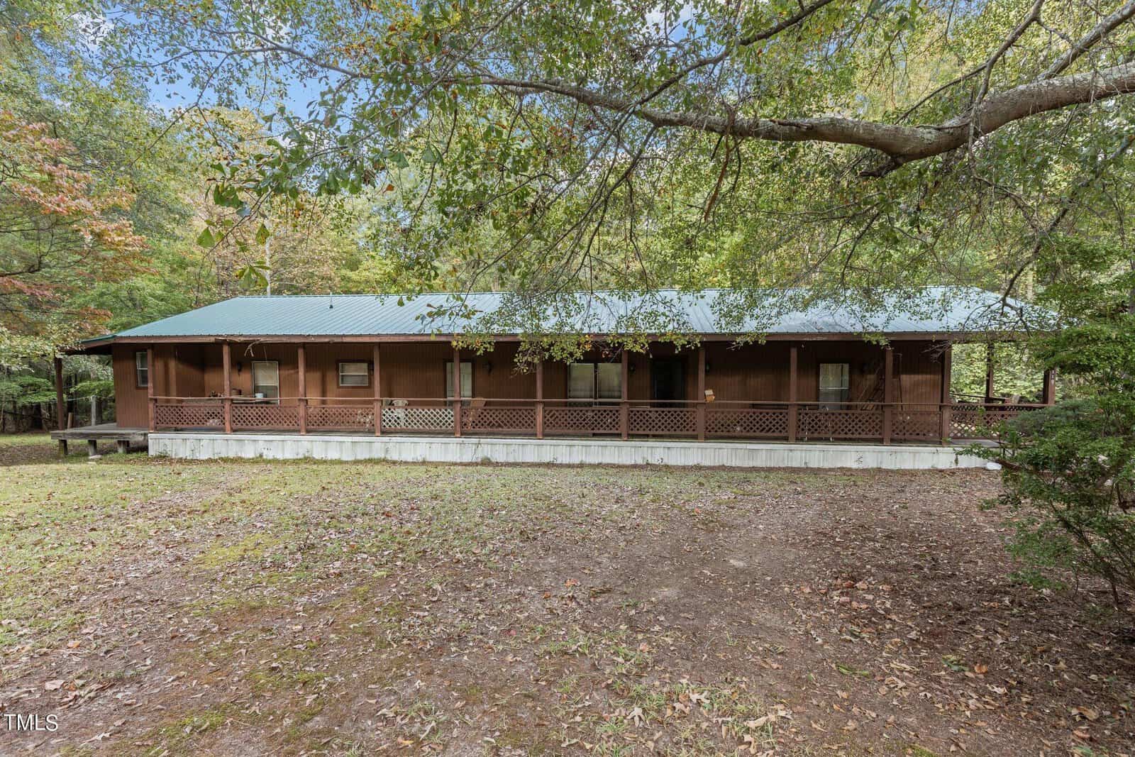 A house with a porch and a large yard.