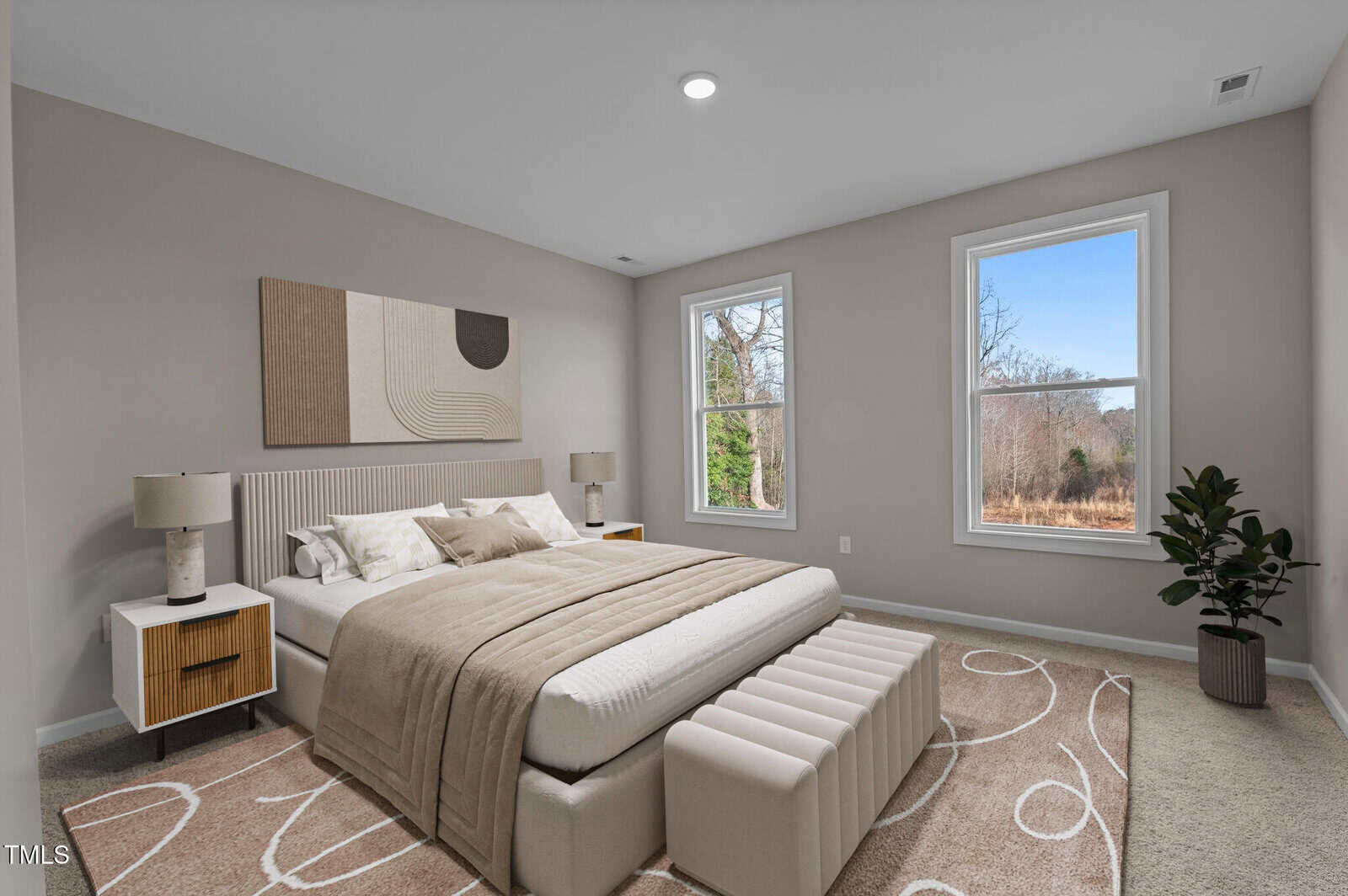 A bedroom with a large bed, two nightstands with lamps, abstract wall art, a bench at the foot of the bed, two windows with outside view, a potted plant, and a beige patterned rug on the carpeted floor.