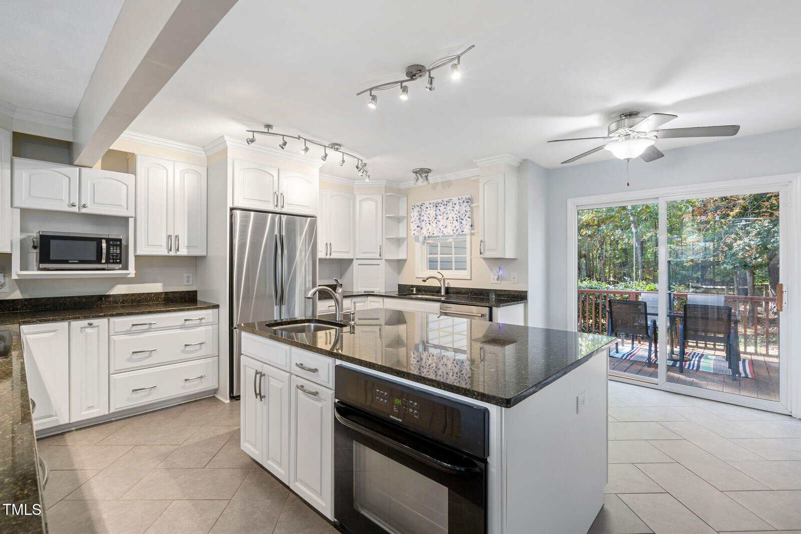 A kitchen with a large island and a refrigerator.