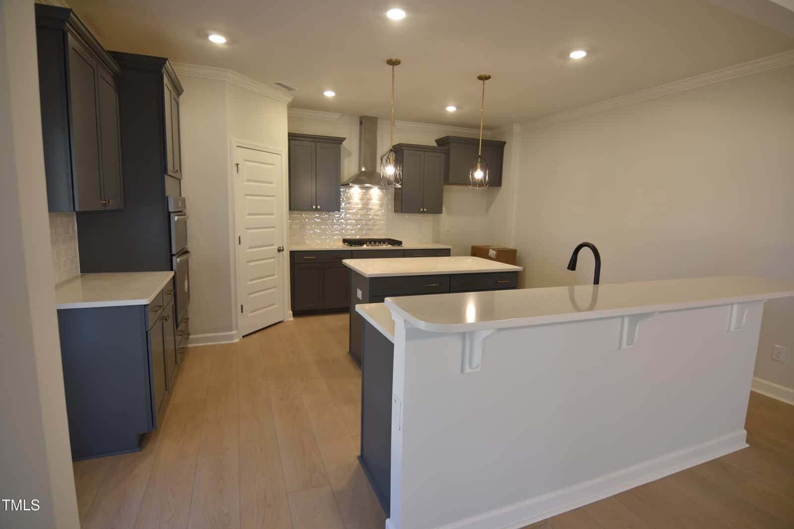 A kitchen with island and cabinets.