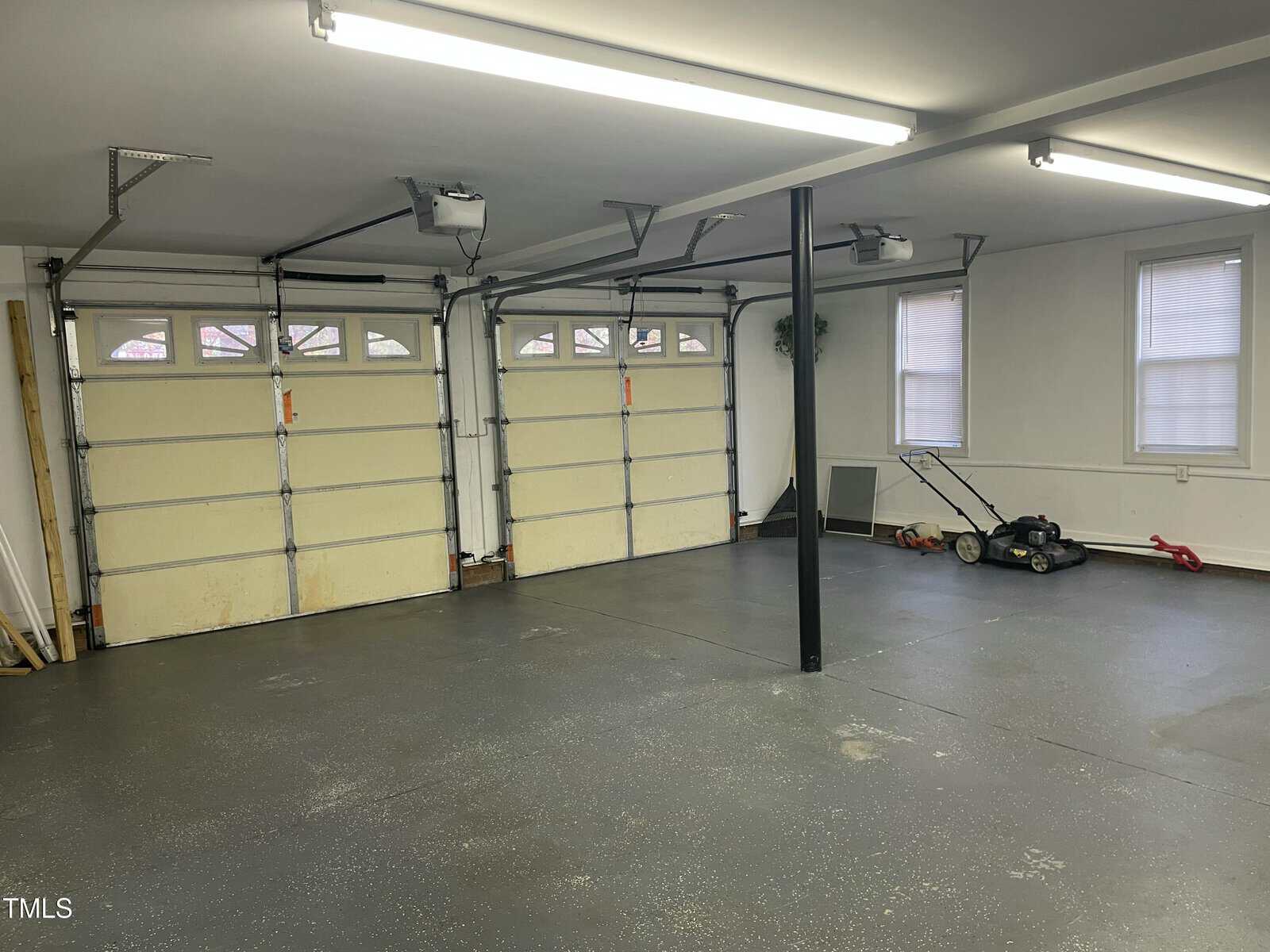 A garage with a lawn mower.
