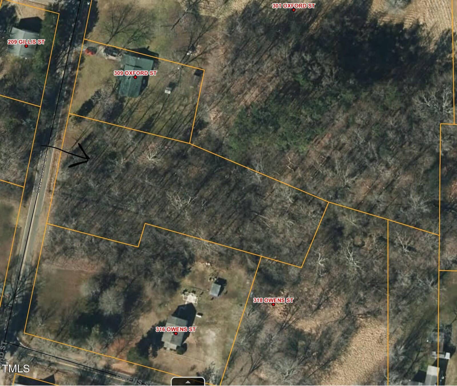 This is an aerial view of a wooded area with houses nearby. Streets are labeled, including Oak Ridge Street, Owens Street, and Oxford Street. Property lines are outlined in yellow. A black arrow is marked on the image.