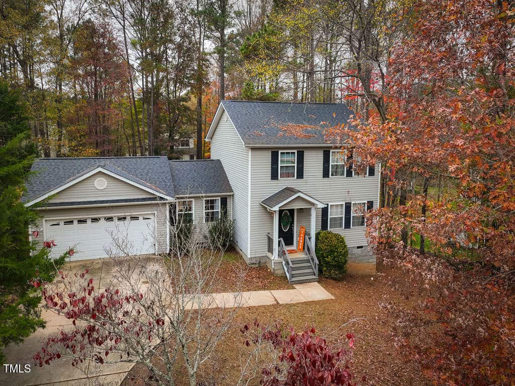 A house with a driveway and trees.