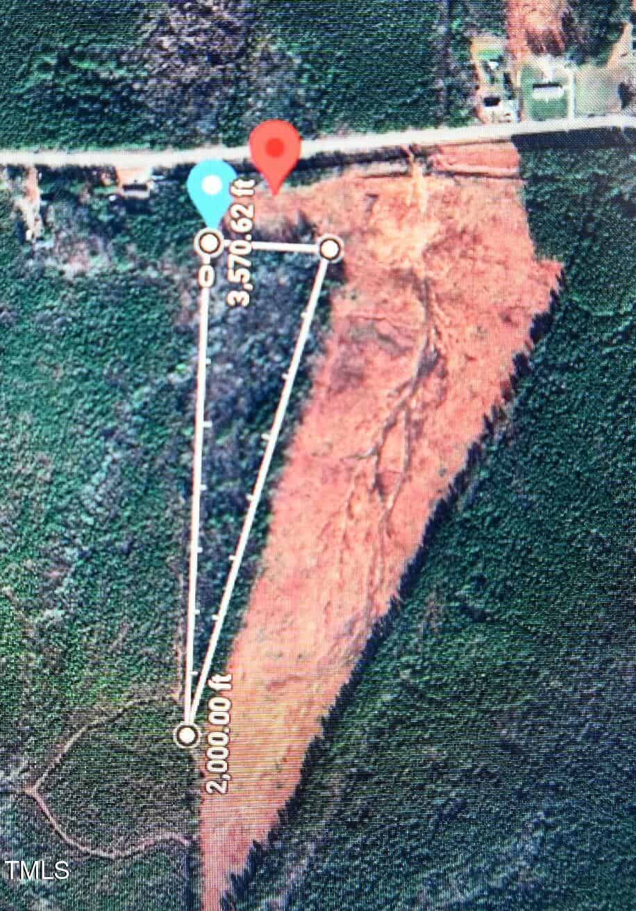 Satellite image showing a triangular outlined land parcel with labeled side lengths, surrounded by dense trees and a cleared area, near a road and a few buildings in Warrenton, specifically at 1080 Lickskillet Road.