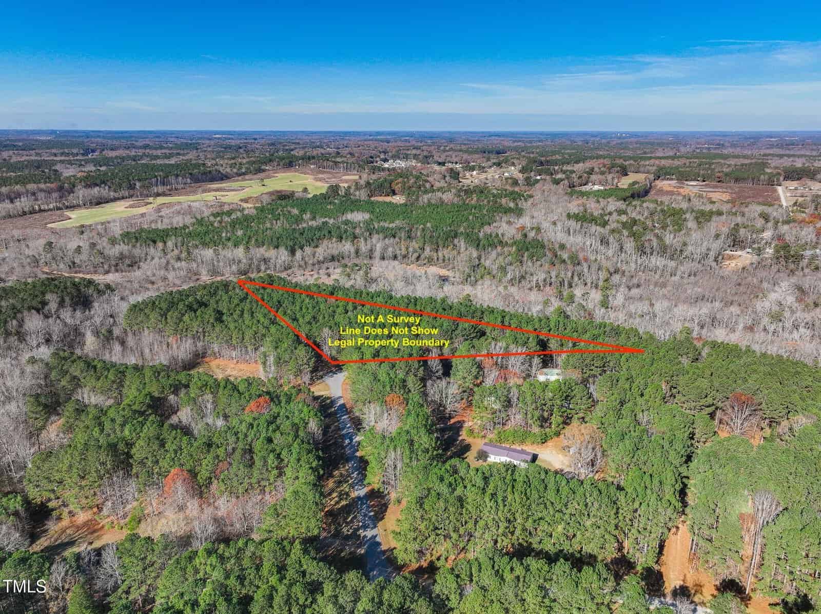 Aerial view of a wooded landscape with a triangular area outlined in red, labeled as “Not a Survey.” The surrounding area features dense trees and a few scattered houses.