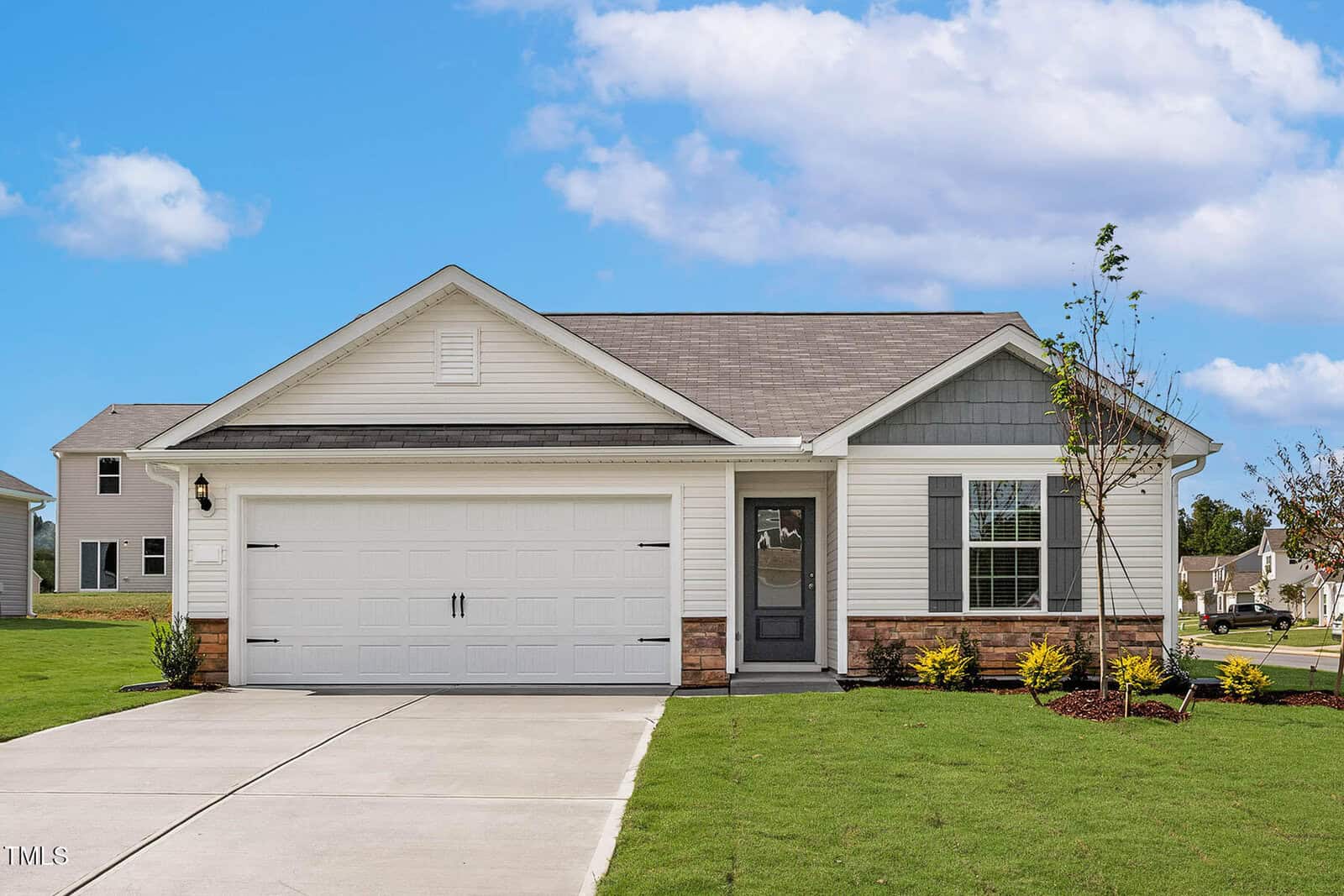 Located at 913 Rhino Bend, this charming single-story house in Oxford features a gray roof, white siding, and a spacious two-car garage. The modest front yard boasts young trees and shrubs under a blue sky with scattered clouds. Neighboring houses provide a welcoming community backdrop.