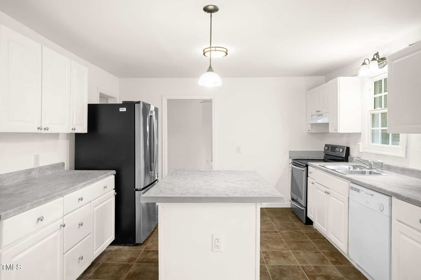 A modern kitchen with white cabinets, a central island, and stainless steel appliances including a refrigerator, oven, and dishwasher. The floor is tiled in brown, and there is overhead lighting.