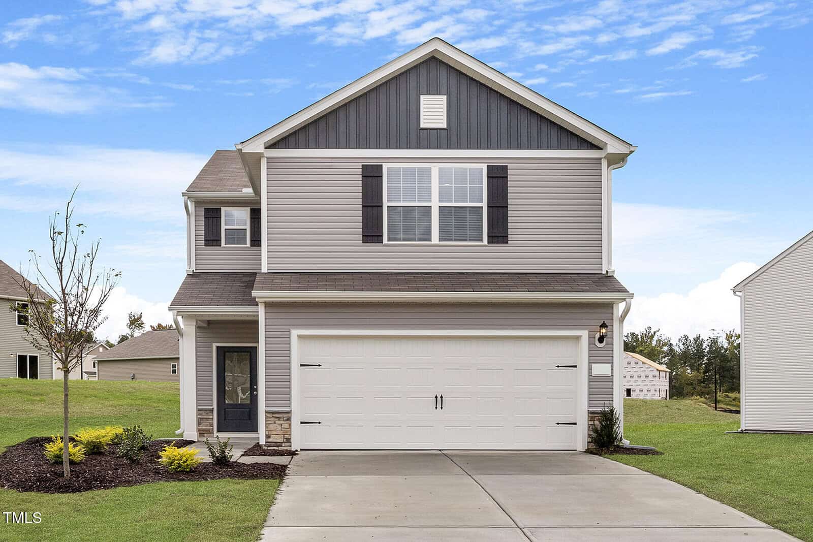 Located at 107 Scoville Street in Oxford, this charming two-story house boasts light gray siding with dark gray accents. It features a two-car garage and a quaint front porch. The landscaped yard offers minimal shrubbery, while the concrete driveway welcomes you under a partly cloudy sky.
