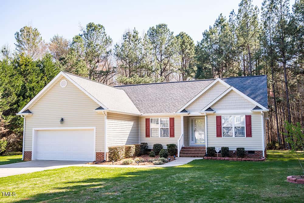 Located at 1516 Bradsher Drive, this charming single-story house with beige siding, white trim, and red shutters features a two-car garage and a quaint front porch. Surrounded by a neatly trimmed lawn and tall trees, it offers the perfect stem of tranquility in suburban living.