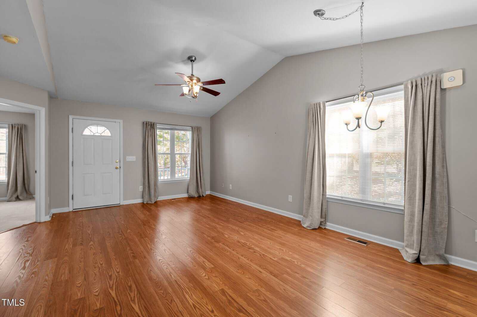 A room with a wood floor and a ceiling fan.