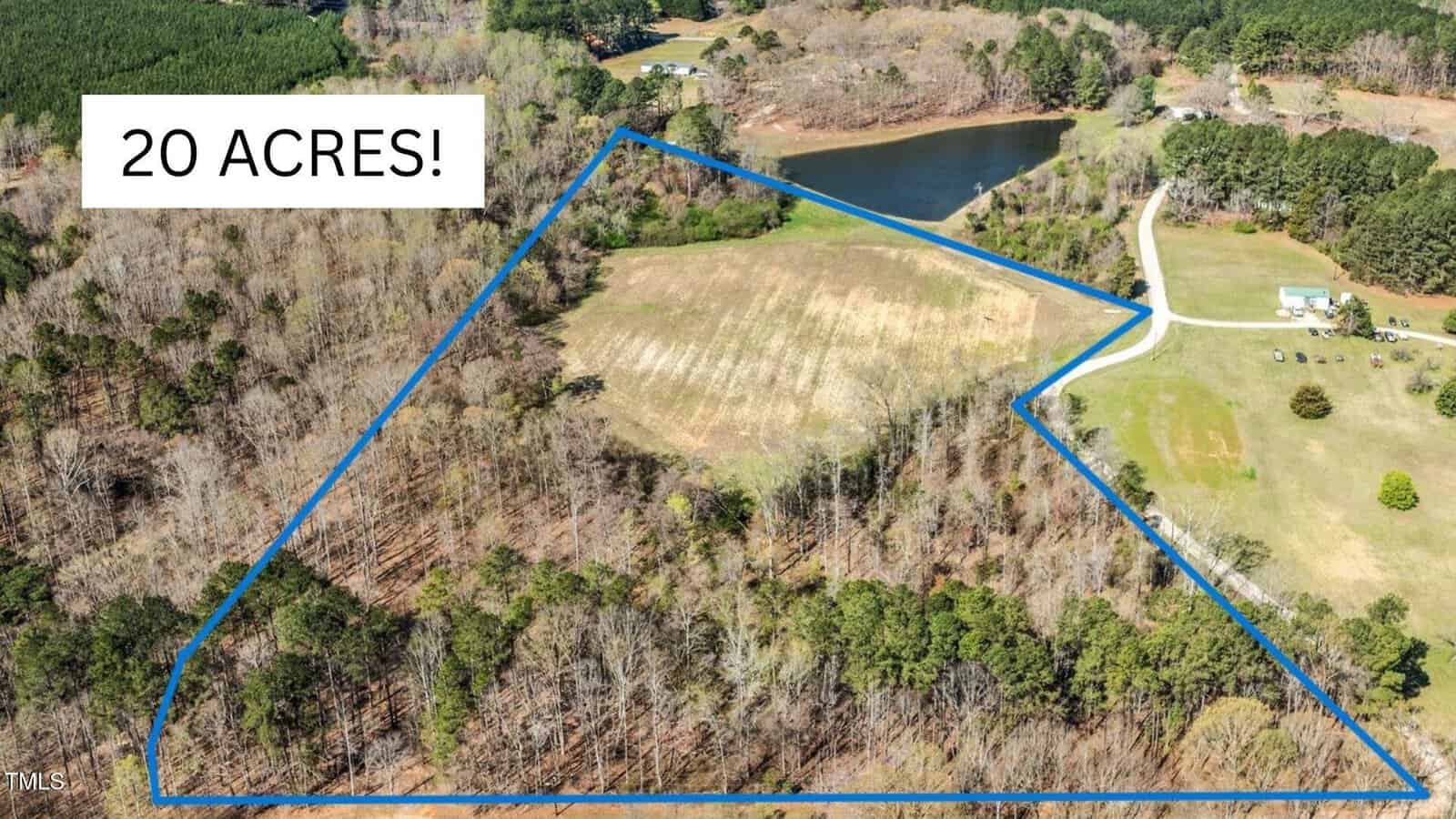 Aerial view of a 20-acre rural property at 11b Riggans Way, Franklinton, with a blue outline, showing wooded areas, open fields, a pond, a farmhouse, and a driveway. A label in the top left corner reads “20 ACRES!”.