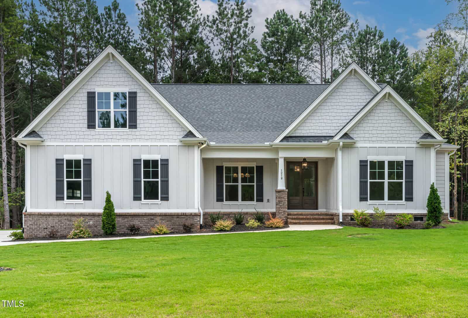 A house with a lawn at 1218 Red Cedar Court in Youngsville, with the Robert Frost Farm in the background.