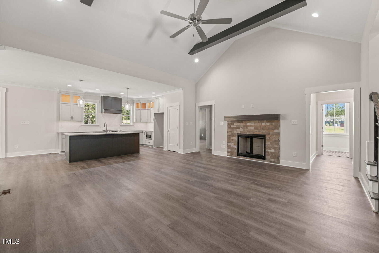 A large open floor plan with a fireplace and a kitchen.