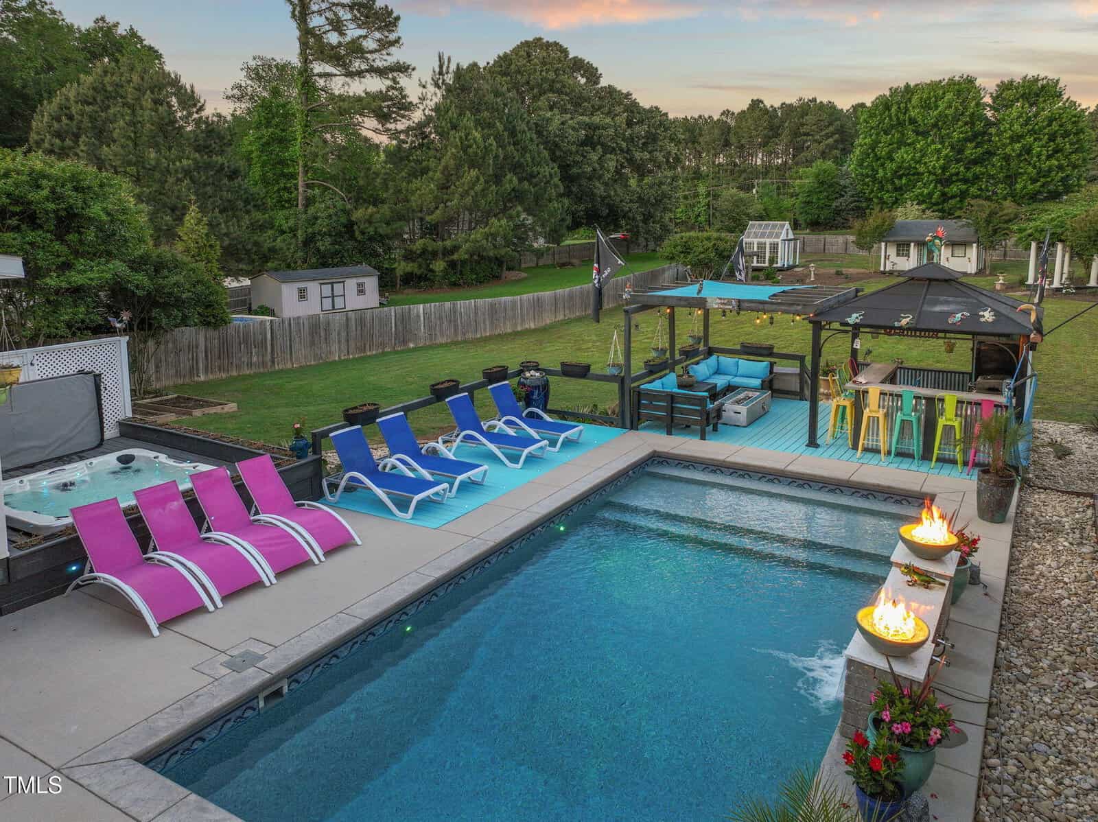 A pool with chairs and a fire pit.