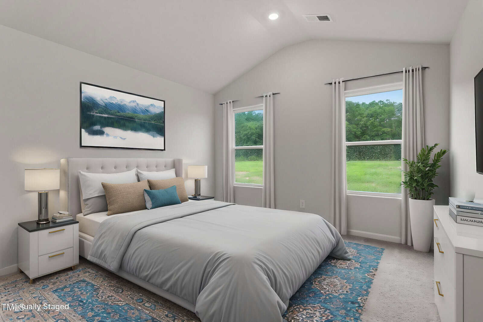 A modern bedroom with a large bed, gray bedding, two nightstands with lamps, two windows showing greenery outside, a blue-patterned rug, a wall-mounted TV, and a landscape picture above the bed.