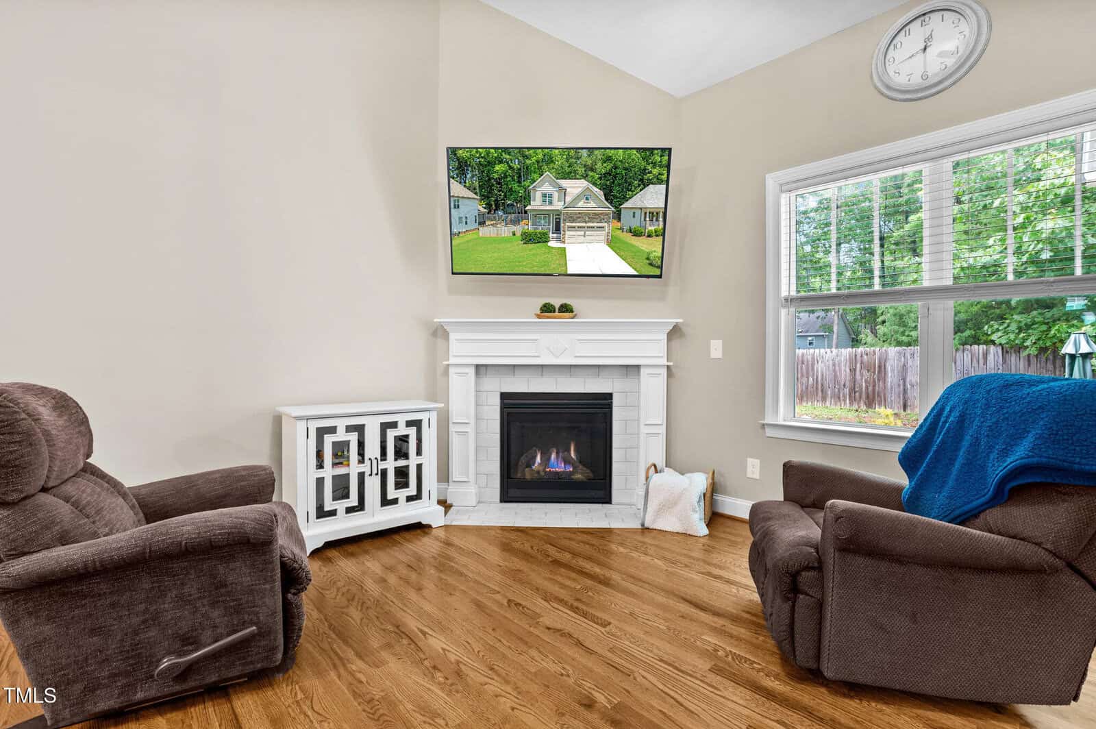 A living room with a fireplace and a television.