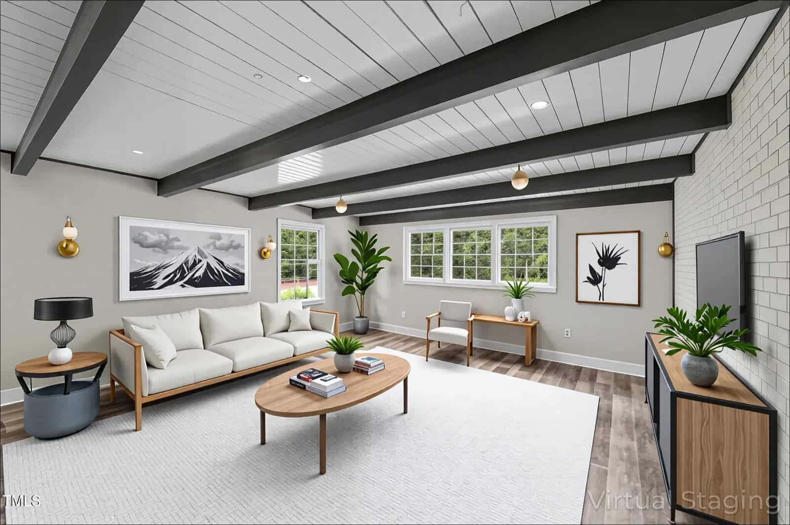 A modern living room with white walls, exposed dark ceiling beams, large windows, a white sofa, wooden furniture, plants, two wall art pieces, and a wall-mounted TV. The words “Virtual Staging” appear in the corner.