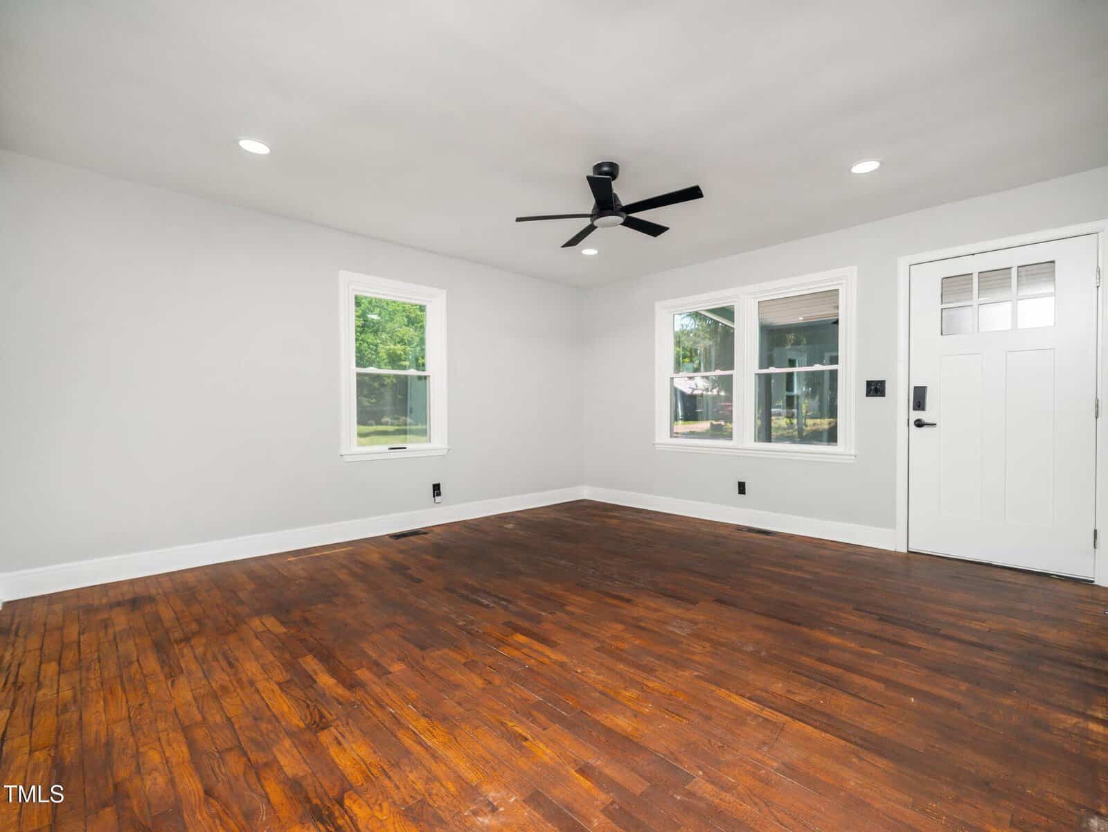 A room with a door and a wood floor.