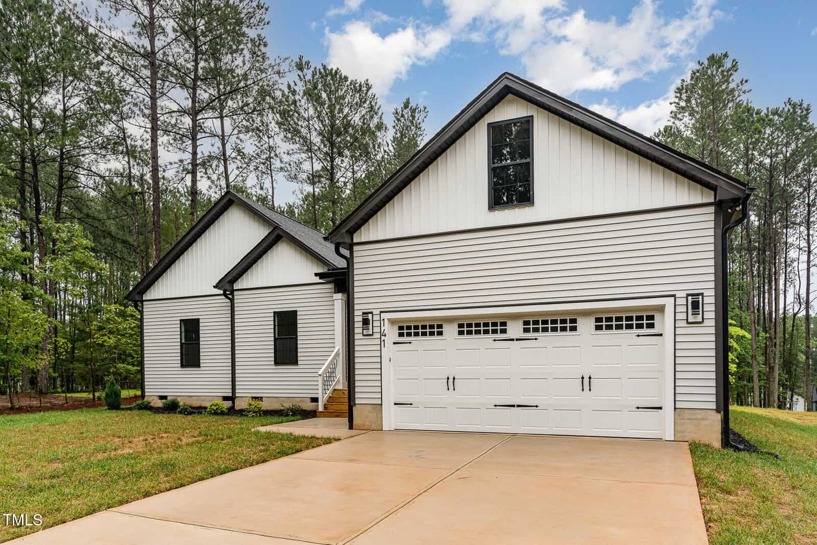 A house with a driveway and trees.